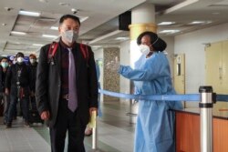 FILE - Passengers arriving from a China Southern Airlines flight from Changsha in China are screened for the coronavirus, upon their arrival at the Jomo Kenyatta international airport in Nairobi, Kenya, January 29, 2020.