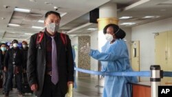 FILE - Passengers arriving from a China Southern Airlines flight from Changsha in China are screened for the coronavirus upon their arrival at the Jomo Kenyatta international airport in Nairobi, Kenya, Jan. 29, 2020.