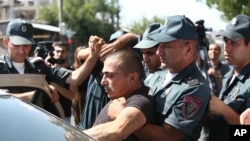 Armenian police detain an unidentified man in Yerevan, Armenia, June 17, 2016. Armed supporters of a jailed opposition leader attacked a police station in Armenia's capital on Sunday.