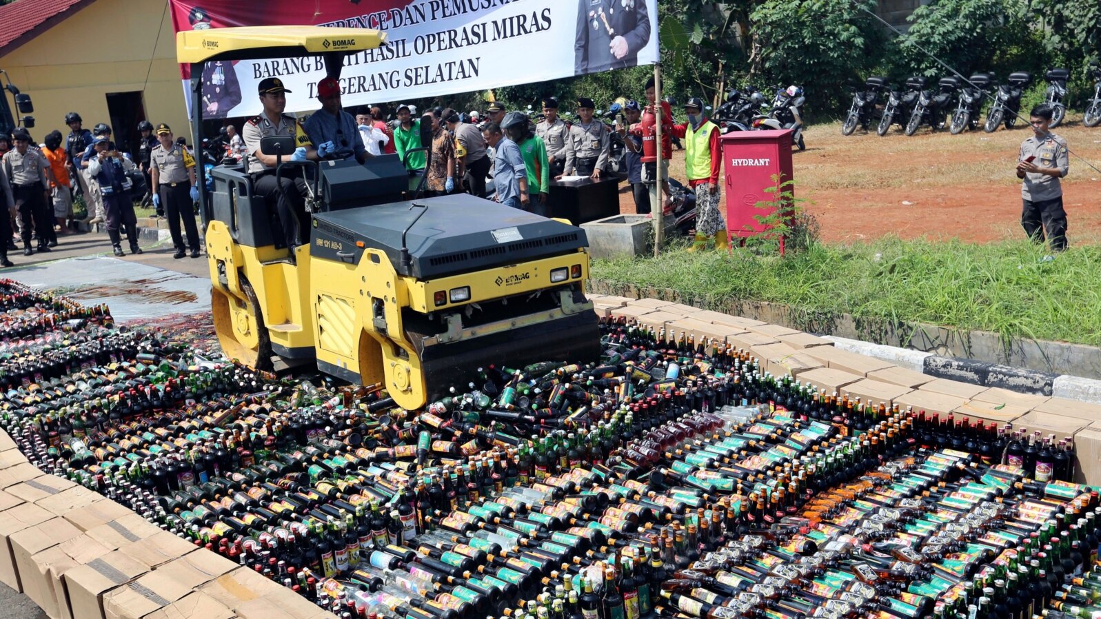 Police use a road roller to destroy bottles of illegal alcohol confiscated in Serpong, out of Jakarta, Indonesia, April 13, 2018.