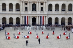 French President Emmanuel Macron pays his respects to the 13 French soldiers killed in Mali, in front of the flag-draped coffins, during a ceremony at the Hotel National des Invalides in Paris, Dec. 2, 2019.