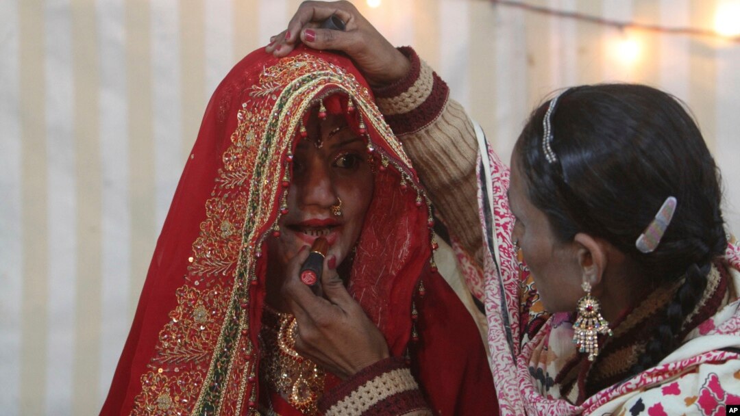 Seorang perempuan memberi hiasan wajah kepada calon pengantin Hindu sebelum pernikahannya di Karachi, Pakistan (foto: ilustrasi). Pakistan meloloskan UU baru untuk melindungi hak perkawinan masyarakat minoritas Hindu.