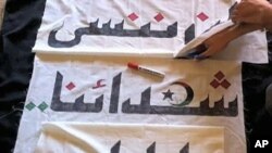 In this picture sent secretly to a VOA e-mail account, Libyan anti-government activists sew the flag of the revolution. The banner reads, 'We will never forget our martyrs'