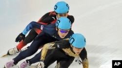 FILE - Japan's Kei Saito leads in front of Thomas Insuk Hong, of the United States, and China's Lu Xiucheng as they compete in the men's 1000 meter short track speed skating competition in Innsbruck, Austria.