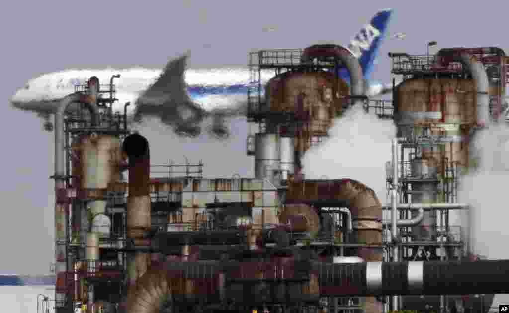 FILE - A passenger plane prepares for landing near an oil refinery in Kawasaki, southwest of Tokyo, Dec. 13, 2018. 