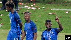 Les Francais Kingsley Coman, Patrice Evra et Paul Pogba, de la gauche vers la droite, quittant le stade après la finale perdue de l'Euro 2016 face au Portugal au Stade de France le 10 juillet 2016 (AP... 