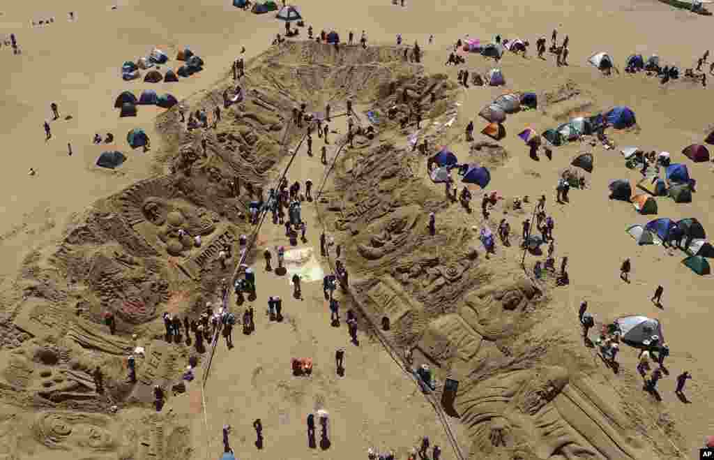 Artistas trabajan en esculturas de arena como parte de las celebraciones del Viernes Santo en los Arenales de Cochiraya, a las afueras de Oruro, Bolivia, el 7 de abril de 2023.