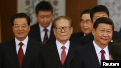 China's President Xi Jinping (R) walks with retired leaders Jiang Zemin (C) and Hu Jintao (L) as they arrive at the National Day Reception to mark the 65th anniversary of the founding of People's Republic of China, at the Great Hall of the People, in Beij