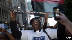 A man holds a bat reading "Black Power" during a protest in Dallas, Texas, to protest the deaths of Alton Sterling and Philando Castile, July 7, 2016.