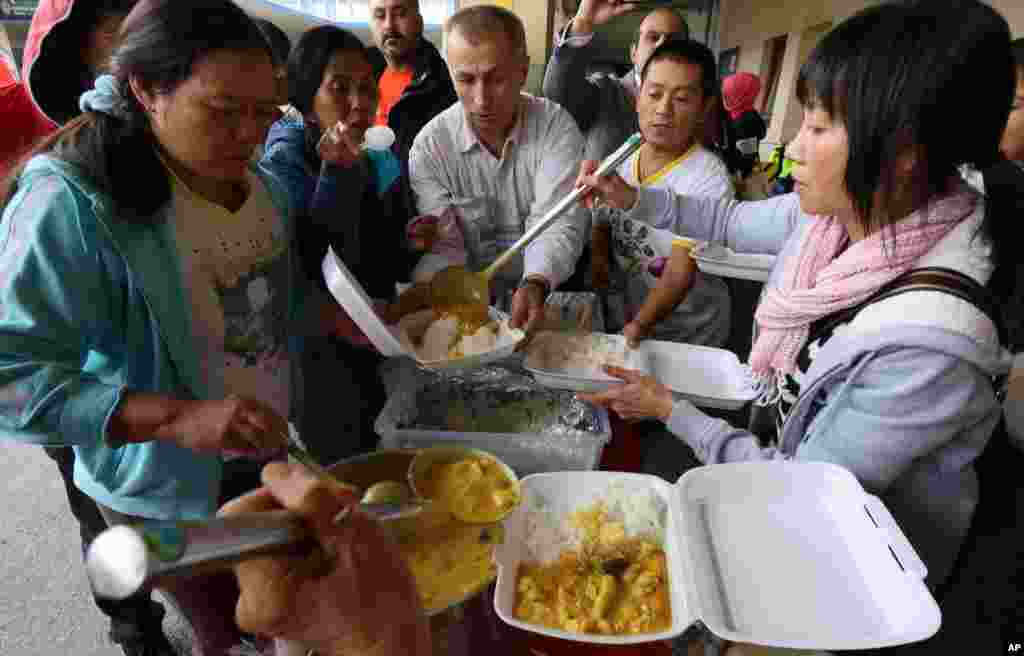 Supporters give warm food to migrants arriving at the Westbahnhof station in Vienna, Austria, Sept. 7, 2015. 