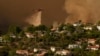 Aircraft drop water on homes as the Palisades Fire advances in Mandeville Canyon on Jan. 11, 2025, in Los Angeles.