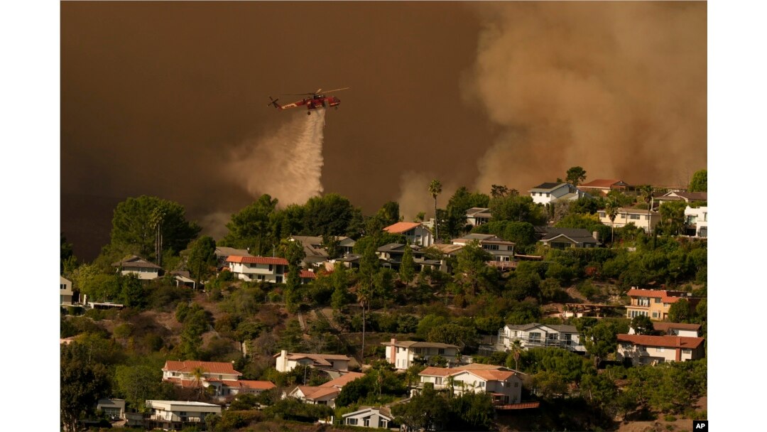 Aircraft fight the Palisades Fire as the blaze advances in Mandeville Canyon in Los Angeles, Jan. 11, 2025.