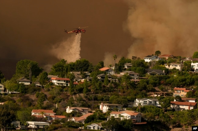 Aircraft fight the Palisades Fire as the blaze advances in Mandeville Canyon in Los Angeles, Jan. 11, 2025.