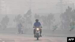 Commuters make their way amid smog in Lahore on Nov. 2, 2024. 