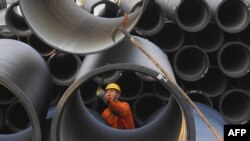 Un ouvrier assemble un lot de tuyaux coulés dans le port de Lianyungang, province du Jiangsu, Chine, le 30 novembre 2017.