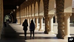 FILE - In this March 14, 2019, file photo students walk on the Stanford University campus in Santa Clara, Calif.
