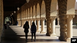 FILE - FILE - In this March 14, 2019, file photo students walk on the Stanford University campus in Santa Clara, Calif.