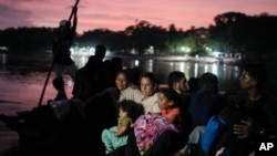 La migrante venezolana Lisbeth Contreras y sus hijos cruzan el río Suchiate, que marca la frontera entre Guatemala y México, desde Tecún Umán, el 26 de octubre de 2024.