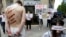 FILE - Reporters Without Borders activists, bound and made up as mock victims, demonstrate outside the Iran Air office on the Champs Elysées in Paris, July 10, 2012, to protest the imprisonment of Iranian journalists.