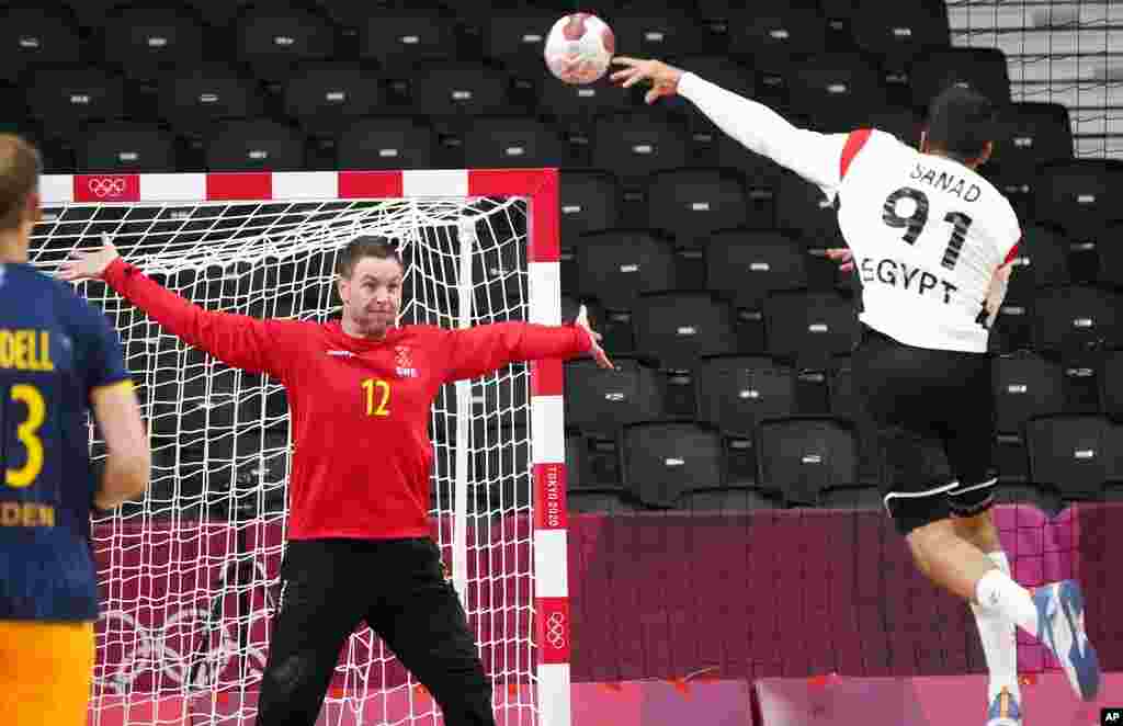 Egypt&#39;s Mohammad Sanad scores a goal past Sweden&#39;s goalkeeper Andreas Palicka during the men&#39;s preliminary round group B handball match between Sweden and Egypt at the 2020 Summer Olympics, Friday, July 30, 2021, in Tokyo, Japan. (AP Photo/Sergei Grits)