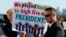 President Donald Trump holds a sign given to him by a crowd of supporters after landing at Dallas Love Field airport, Oct. 25, 2017, in Dallas.