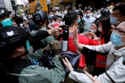 FILE PHOTO: Anti-government demonstrators scuffle with riot police during a lunch time protest as a second reading of a controversial national anthem law takes place in Hong Kong, May 29, 2020.