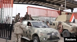 FILE - Syrian forces cross the border through gates at Al-Qaim, Iraq, in this image released Dec. 7, 2024. Iraq sent nearly 2,000 Syrian soldiers back to Syria Dec. 19; they had sought refuge in Iraq during the rebel push to oust Bashar al-Assad.