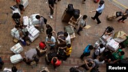 A policeman (top, R) asks mainland Chinese visitors to unblock a pavement outside Hong Kong's Sheung Shui train station, Aug. 23, 2012. 