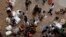 A Hong Kong policeman (top, R) asks mainland Chinese visitors to unblock a pavement outside Hong Kong's Sheung Shui train station, Aug. 23, 2012. 