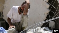 Un homme cherche des survivants après l'effondrement d'un bâtiment au nord de la ville d'Alep, Syrie, le 17 juillet 2016.