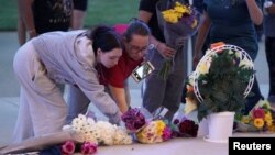 People lay flowers while attending a vigil at Jug Tavern Park following a shooting at Apalachee High School in Winder, Georgia, Sept. 4, 2024. 