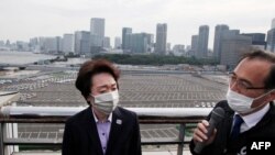 Seiko Hashimoto, president of the Tokyo 2020 Organizing Committee of the Olympic and Paralympic Games, (L) listens to an explanation by Masayuki Kanda, Tokyo 2020 elective director of Transport, during her visit to Tsukiji Depot in Tokyo, May 25, 2021.