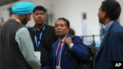 O ativista Harjeet Singh, à esquerda, fala com o Enviado Especial para o Clima de Timor-Leste, Adão Soares Barbosa, durante a Cimeira do Clima da ONU COP29, sábado, 23 de novembro de 2024, em Baku, Azerbaijão.