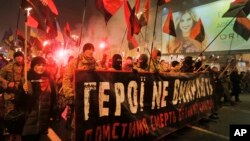 Ukrainian nationalists carry torches and a banner reading "Heroes do not die" during a rally in downtown Kyiv, Ukraine, Jan. 1, 2015.