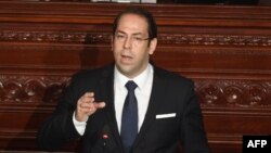 FILE - Tunisian Prime Minister Youssef Chahed addresses the parliament in Tunis on the country's anti-corruption fight, July 20, 2017.