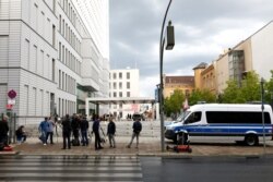 FILE - Members of the media stand outside the Charite Mitte Hospital Complex, where Russian opposition leader Alexei Navalny is receiving medical treatment, in Berlin, Aug. 24, 2020.