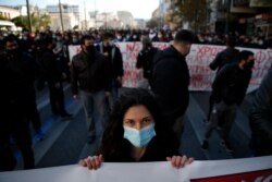 A university student holds a banner during a rally against education reforms in Athens, Jan. 28, 2021.