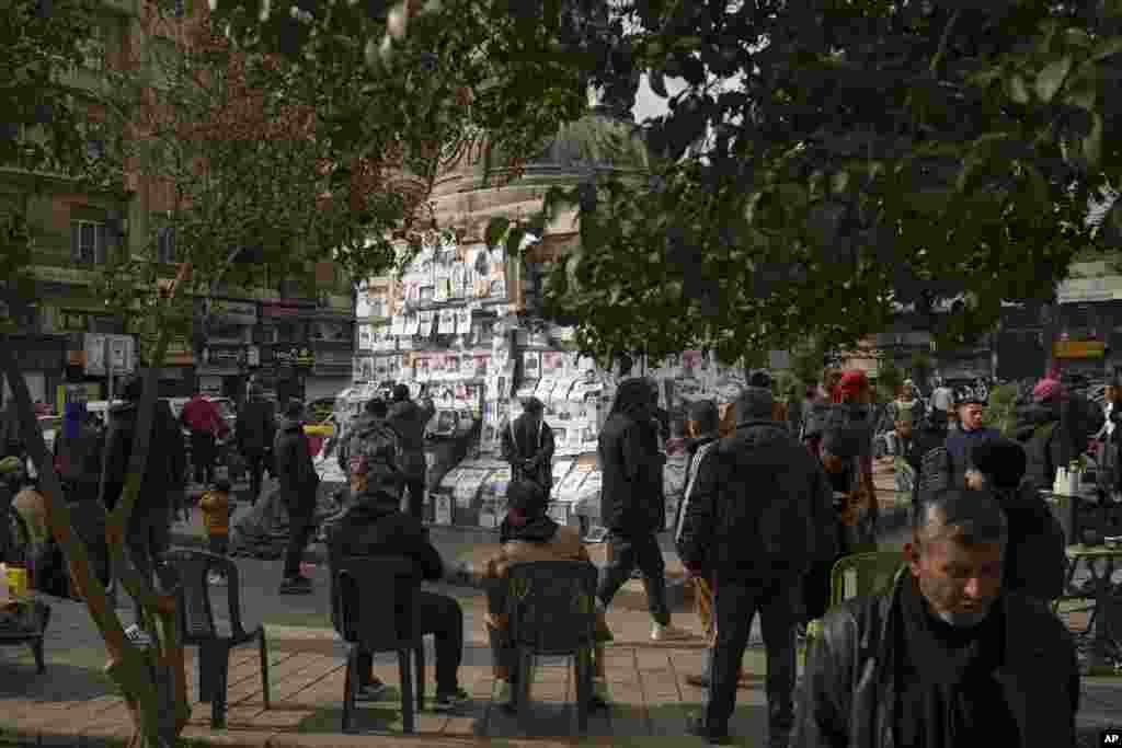 Syrians look at photos of people reported to be missing, by members of ousted President Bashar al-Assad&#39;s army or a pro-government militia, at the Marjeh square in Damascus.