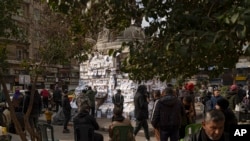 Syrians look at photos of people reported to be missing, by members of ousted President Bashar al-Assad&#39;s army or a pro-government militia, at the Marjeh square in Damascus.