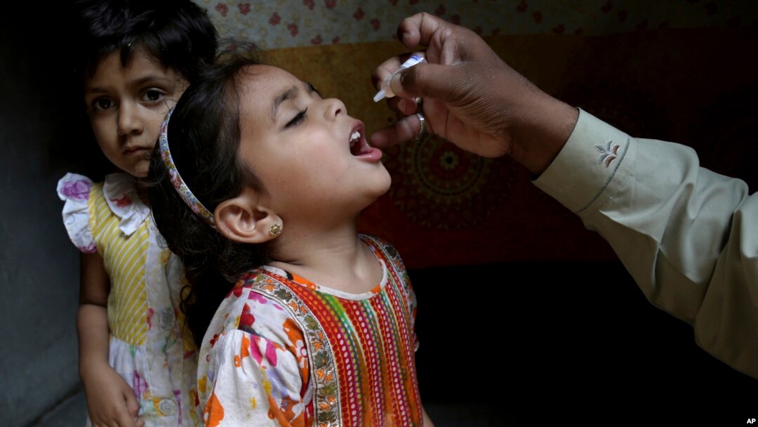 ARSIP - Seorang pekerja kesehatan memberikan vaksin polio ke seorang anak perempuan di Lahore, Pakistan, Senin, 9 April 2018 (foto: AP Photo/K.M. Chaudary)