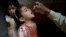 A health worker gives a polio vaccine to a girl in Lahore, Pakistan, April 9, 2018. A Pakistani official said authorities launched a new polio vaccination drive, aiming to reach 38.7 million children younger than 5.