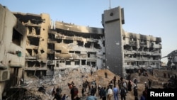 FILE— Palestinians inspect damage at Al Shifa Hospital after Israeli forces withdrew from the hospital and the area around it following a two-week operation, in Gaza City April 1, 2024.
