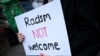 A protester holds a placard during a counter demonstration against an anti-immigration protest called by far-right activists, outside the Asylum Welcome immigration support service offices in Oxford, western England on Aug. 7, 2024.