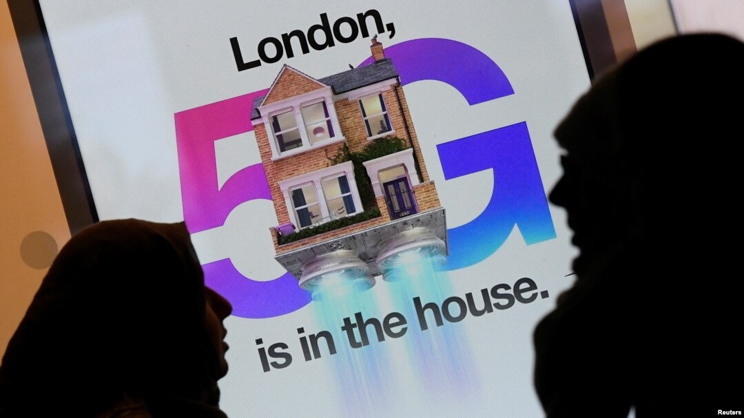 Dua warga Inggris melewati iklan jaringan 5G di sebuah toko ponsel di London (foto: ilustrasi). 