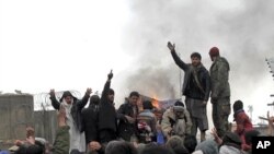 Afghan men shout anti-U.S slogans during a protest outside the U.S. military base in Baghram, north of Kabul February 21, 2012.