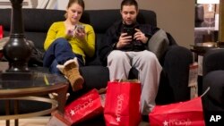 Andrea and Karl Galvez of Chicago take a break from shopping during Black Friday shopping at Macy's on Nov. 29, 2013, in Chicago.