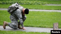 U.S. Army Reserve Sgt. Edwin morales kneels as he honors his cousin Ruben Correa during ceremonies marking the 17th anniversary of the September 11, 2001 attacks on the World Trade Center, at the National 9/11 Memorial and Museum in New York, September 11