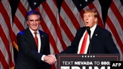 ARCHIVO - El presidente electo de EEUU, Donald Trump, estrecha la mano del gobernador deDakota del Norte, Doug Burgum, durante un evento de campaña el 8 de febrero de 2024. Trump escogió a Burgum para dirigir el Departamento del Interior.