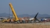 Firefighters and rescue team members work near the wreckage of a Jeju Air Boeing 737-800 series aircraft after the plane crashed and burst into flames at Muan International Airport in South Jeolla Province, Dec. 29, 2024.