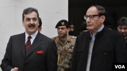 Perdana Menteri Pakistan Yousuf Raza Gilani dari Partai Rakyat Pakistan (kiri) berjalan dengan Presiden Partai Liga Muslim Pakistan Chaudhry Shujaat Hussain (kanan) di Lahore.